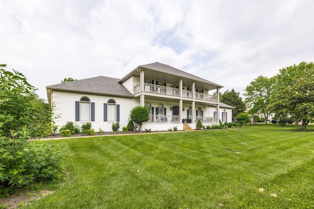 view of front of house featuring a front lawn and a balcony