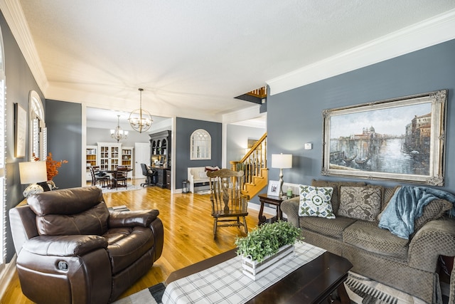 living room featuring a chandelier, hardwood / wood-style flooring, and ornamental molding