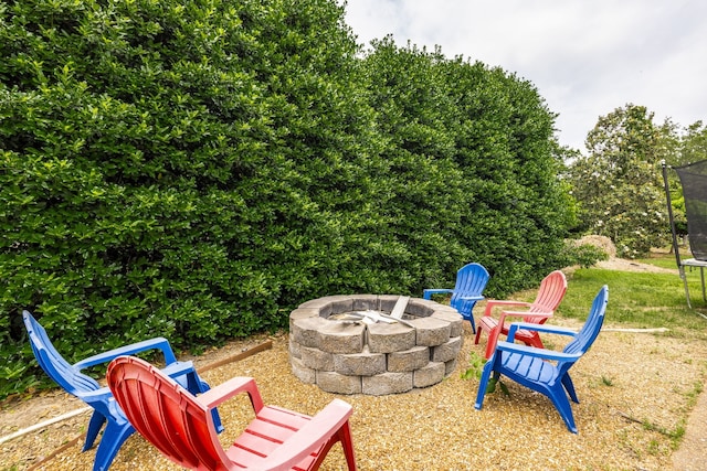 exterior space featuring an outdoor fire pit and a trampoline