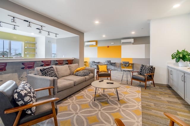 living room with rail lighting and a wall mounted air conditioner