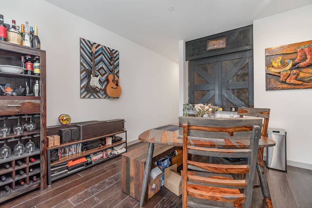 dining space with a barn door and dark hardwood / wood-style floors