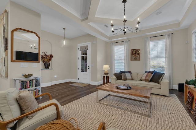 living room featuring hardwood / wood-style floors, coffered ceiling, an inviting chandelier, crown molding, and beam ceiling