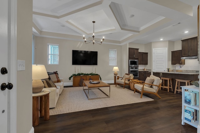 living room featuring ornamental molding, coffered ceiling, sink, a notable chandelier, and dark hardwood / wood-style floors