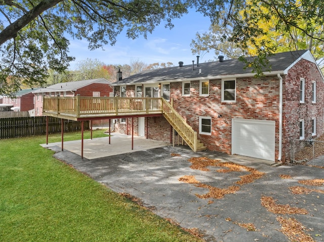 rear view of property with a garage, a yard, and a wooden deck