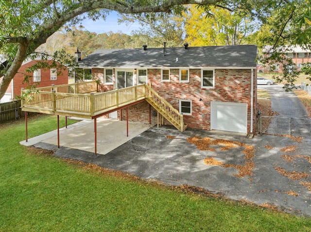 rear view of property featuring a deck, a garage, and a yard