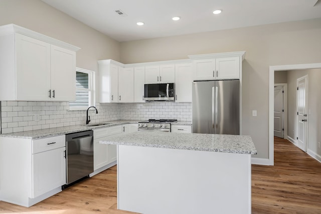 kitchen featuring white cabinetry, stainless steel appliances, sink, and a center island