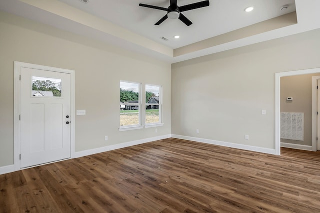 entrance foyer with hardwood / wood-style floors, ceiling fan, and a raised ceiling