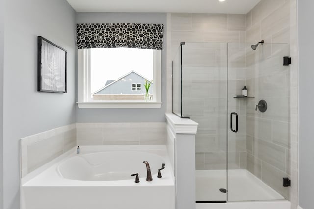 bathroom featuring shower with separate bathtub