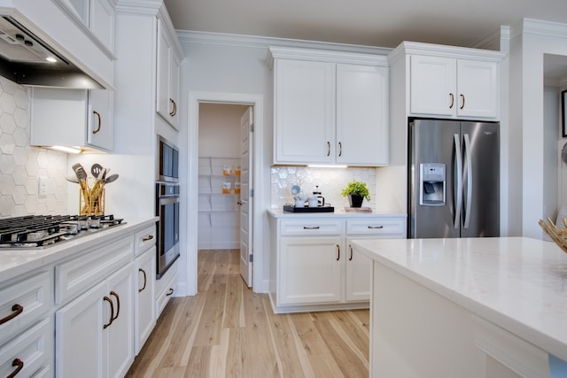 kitchen with premium range hood, white cabinetry, tasteful backsplash, and appliances with stainless steel finishes