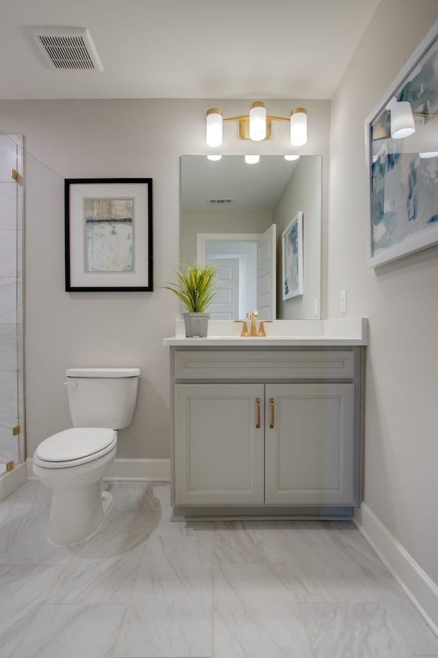 bathroom featuring an enclosed shower, vanity, and toilet