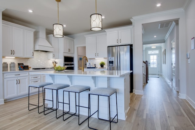 kitchen featuring white cabinetry and custom exhaust hood