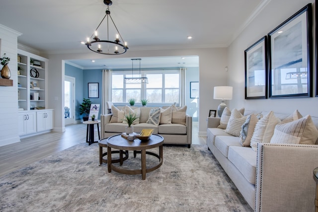 living room with crown molding, light hardwood / wood-style flooring, and a notable chandelier