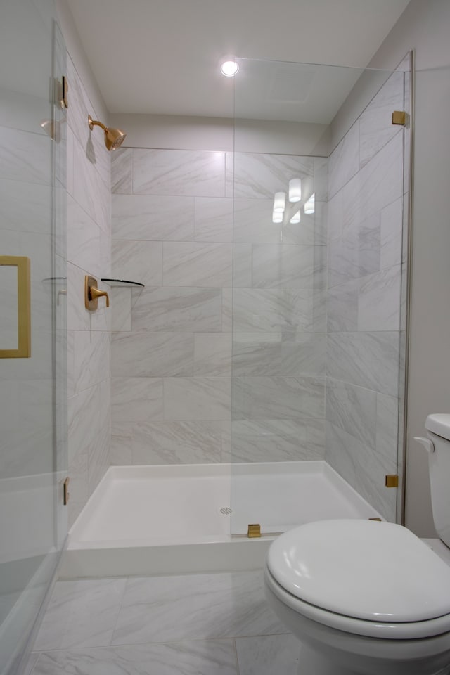 bathroom with a shower with door and toilet