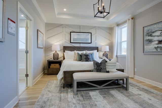 bedroom with ornamental molding, light hardwood / wood-style floors, and a tray ceiling