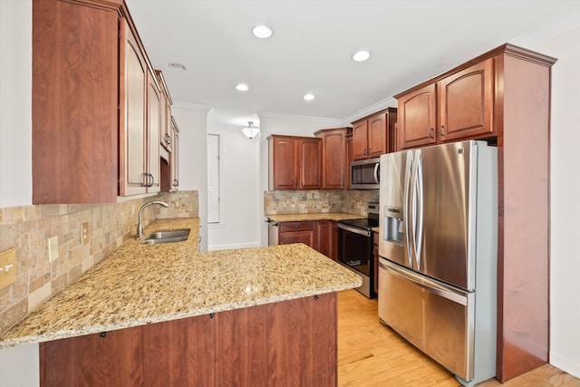 kitchen featuring sink, kitchen peninsula, light stone counters, appliances with stainless steel finishes, and light wood-type flooring