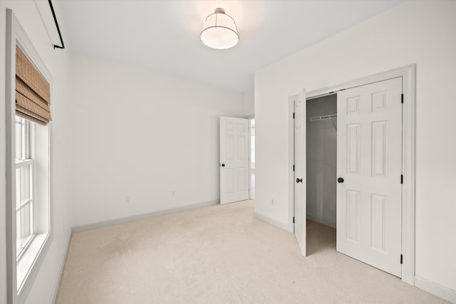 unfurnished bedroom with light colored carpet and a closet