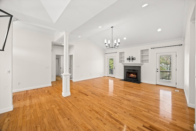 unfurnished living room featuring a chandelier, lofted ceiling, ornamental molding, and light hardwood / wood-style flooring