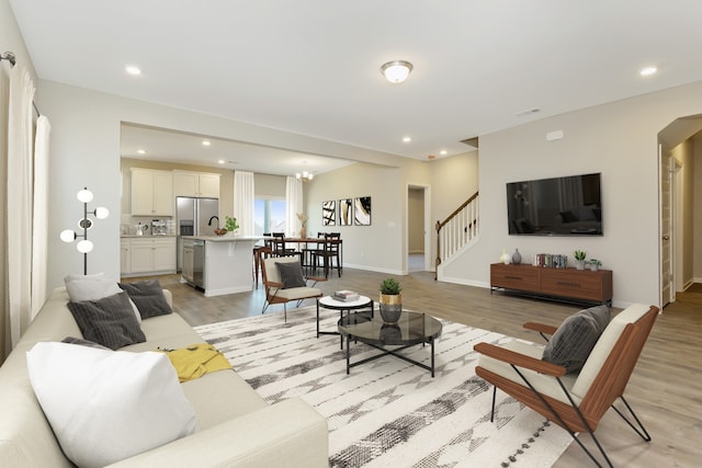 living room with light hardwood / wood-style floors and an inviting chandelier