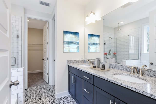 bathroom featuring tile patterned floors, vanity, and a shower with door