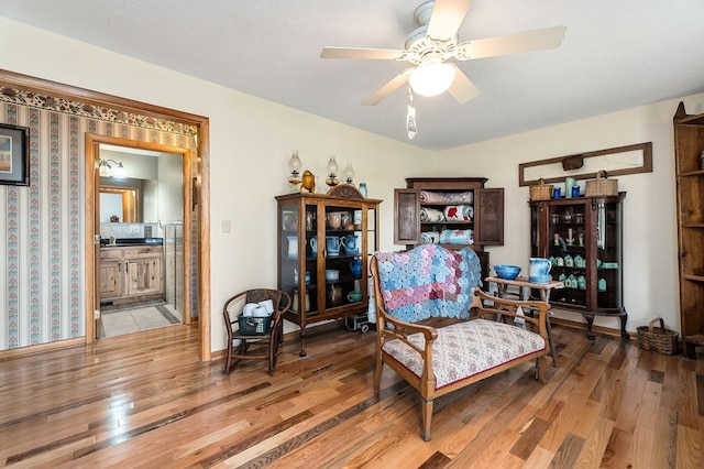 living area featuring ceiling fan, a textured ceiling, and light hardwood / wood-style floors