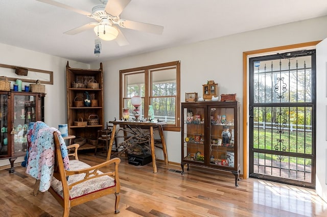 living area with ceiling fan and light hardwood / wood-style flooring