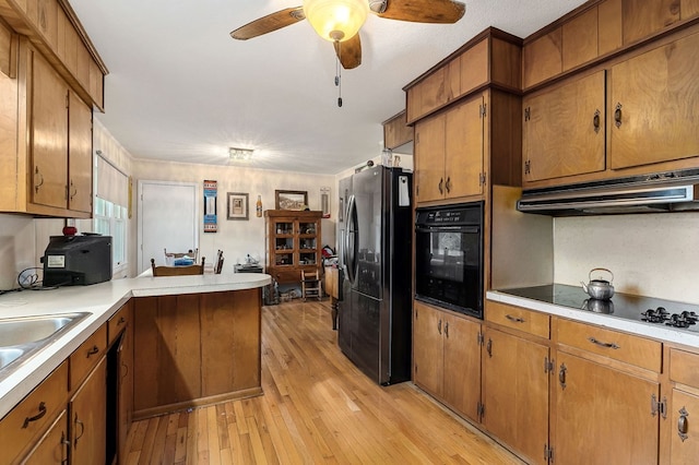 kitchen featuring light hardwood / wood-style floors, kitchen peninsula, black appliances, sink, and ceiling fan