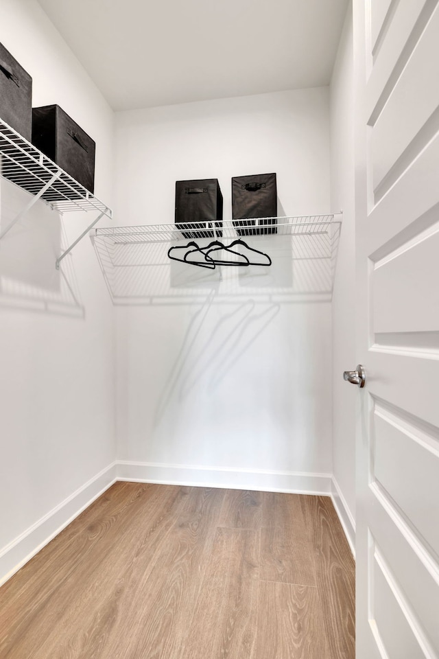 walk in closet with hardwood / wood-style floors