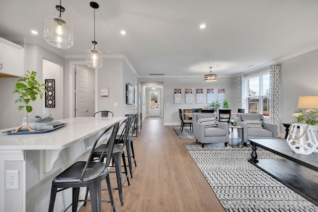 living room with light wood-type flooring and crown molding