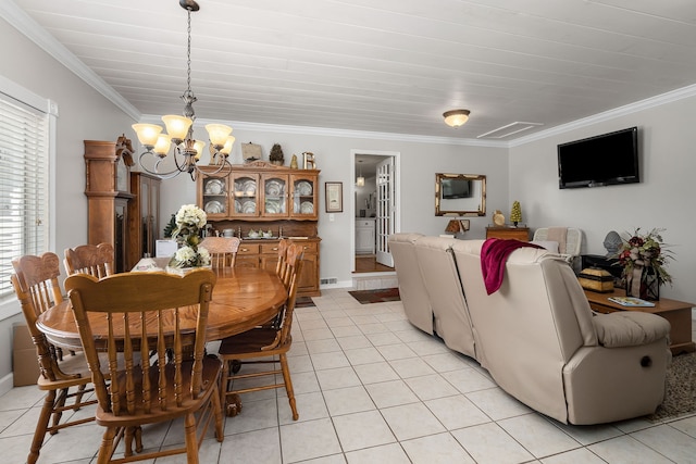 tiled dining area with crown molding and an inviting chandelier