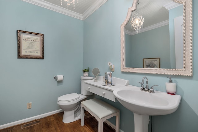 bathroom with toilet, an inviting chandelier, hardwood / wood-style floors, and crown molding