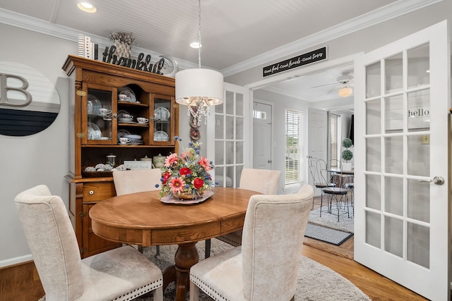 dining space featuring ceiling fan, wood-type flooring, and ornamental molding