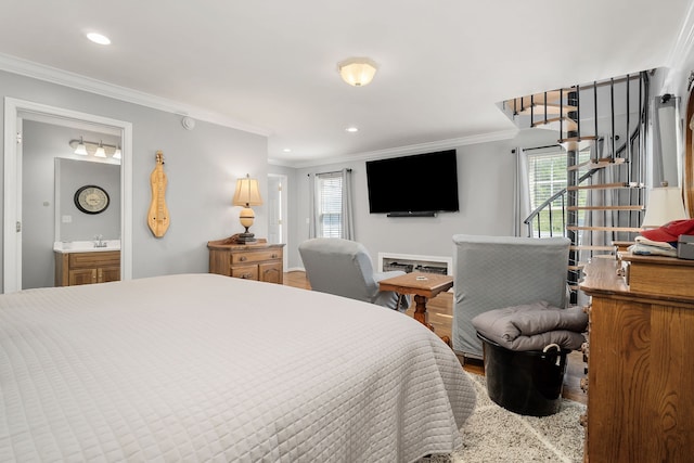 bedroom featuring hardwood / wood-style floors, ornamental molding, and ensuite bath