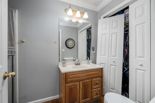 bathroom with vanity, toilet, and crown molding