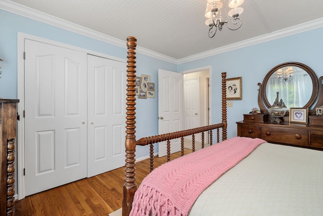 bedroom featuring ornamental molding, hardwood / wood-style floors, a closet, and an inviting chandelier