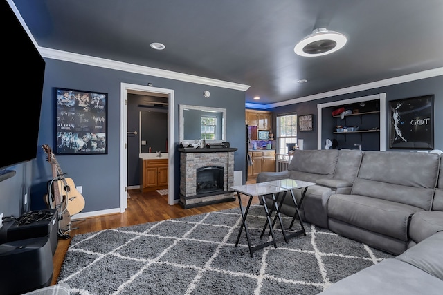 living room with ornamental molding, sink, dark hardwood / wood-style floors, and a fireplace