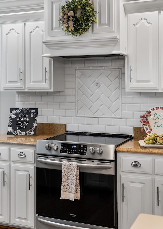 kitchen featuring white cabinetry, decorative backsplash, and stainless steel electric range oven