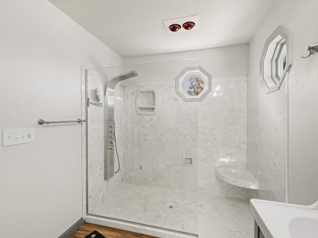 bathroom featuring hardwood / wood-style flooring, vanity, and a tile shower