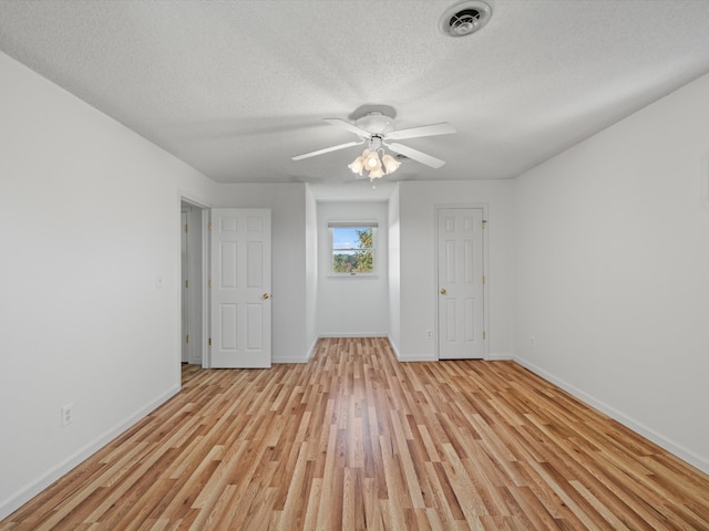 spare room with ceiling fan, a textured ceiling, and light hardwood / wood-style floors