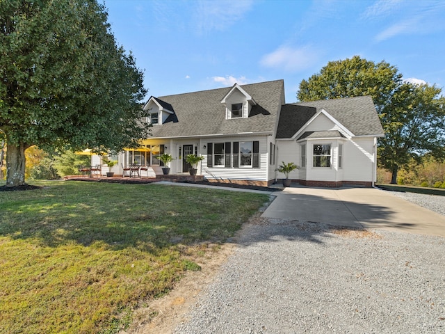 new england style home with a porch and a front lawn