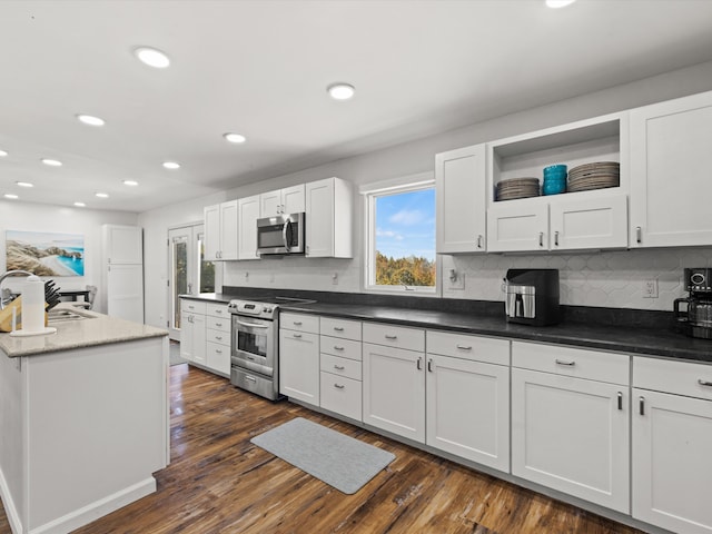 kitchen with white cabinets, sink, dark hardwood / wood-style floors, backsplash, and appliances with stainless steel finishes