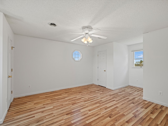 spare room with ceiling fan, a textured ceiling, and light hardwood / wood-style flooring