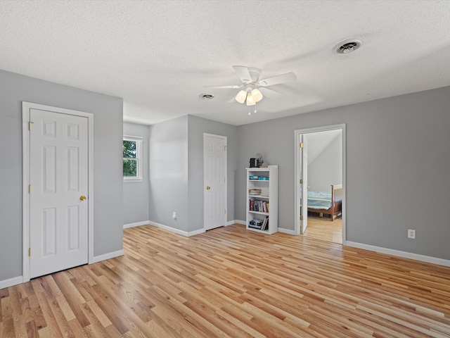 spare room featuring light hardwood / wood-style floors, a textured ceiling, and ceiling fan