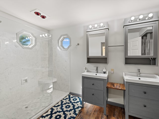 bathroom featuring hardwood / wood-style floors, plenty of natural light, tiled shower, and vanity