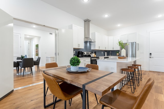 dining area with light hardwood / wood-style floors and sink