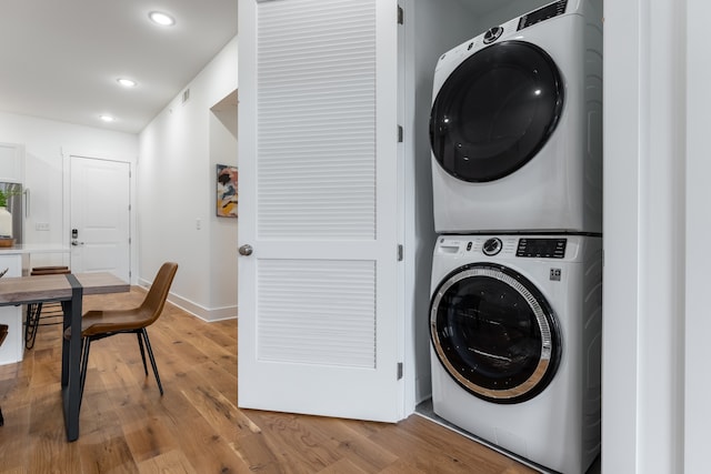 washroom with light wood-type flooring and stacked washer / dryer