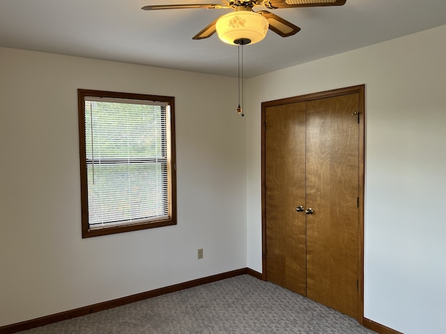 unfurnished bedroom with ceiling fan, a closet, and carpet floors