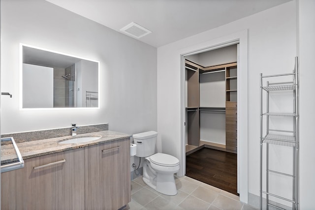 bathroom featuring toilet, a shower, vanity, and wood-type flooring