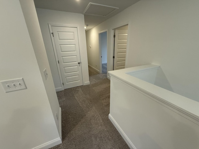 hall with dark colored carpet