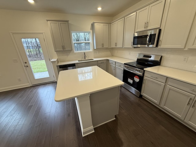 kitchen featuring sink, dark hardwood / wood-style floors, stainless steel appliances, and a kitchen island