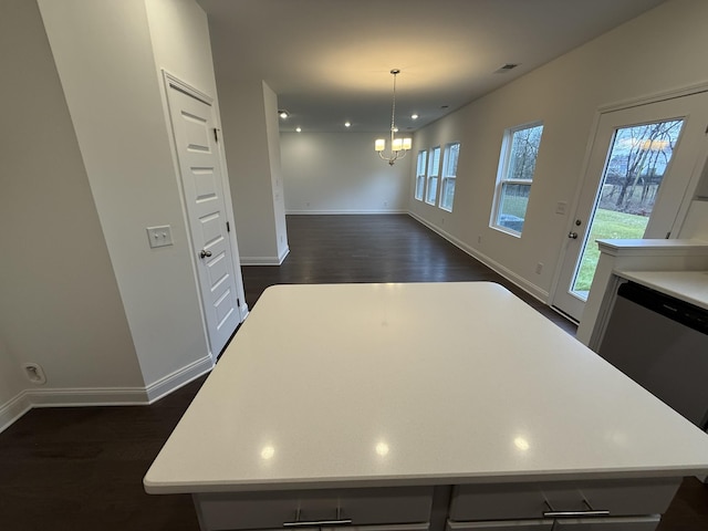 kitchen featuring pendant lighting, dark hardwood / wood-style floors, a center island, and a notable chandelier